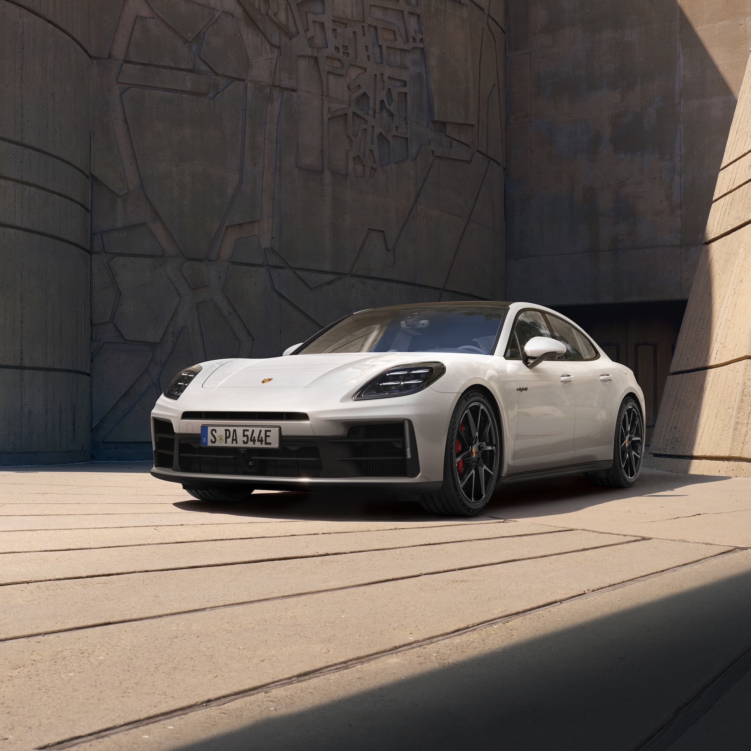 Un Porsche Panamera estacionado frente a un edificio moderno.